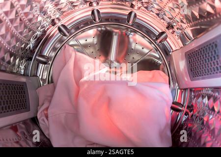 Inside the laundry. A view from inside a washing machine drum, showing colorful clothes, including knits. Stock Photo