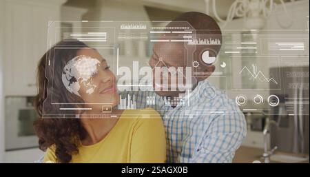 Image of financial data processing over biracial couple in kitchen Stock Photo
