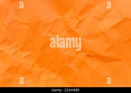 Top view and full frame of wrinkled or crumpled orange paper is used as crumpled orange paper background texture. Stock Photo