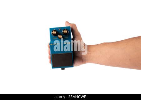 Male hand holding blue guitar effects pedal isolated on white background cutout Stock Photo
