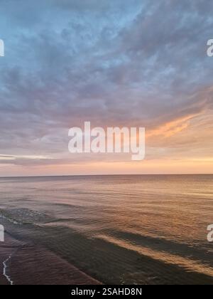 Tranquil ocean sea scene, soft warm hues in the sky, concept of mindfulness, nature retreat, meditation, peaceful and calm, reflections Stock Photo