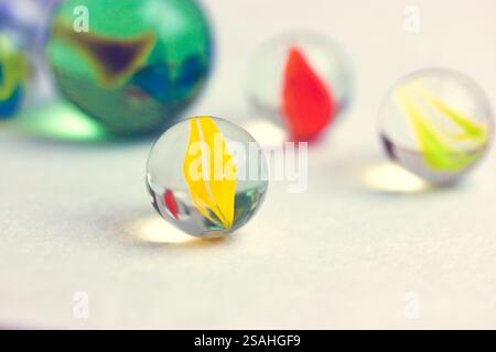 Colourful yellow red green glass balls isolated on white background close up. Marble toys. Congkak is a traditional game in Asia. Marbles wallpapers. Stock Photo