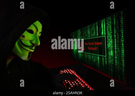 Dnipro. Ukraine. 03 feb 2024: Hacker cracker with anonymous mask working on the computer. Stock Photo