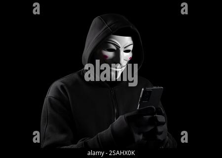 Dnipro. Ukraine 31 jan 2024: Dangerous anonymous hacker man in hooded use smartphone, break security data and hack password with personal Bank account Stock Photo