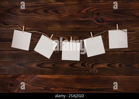 paper cards hanging on the rope on wooden background. Stock Photo