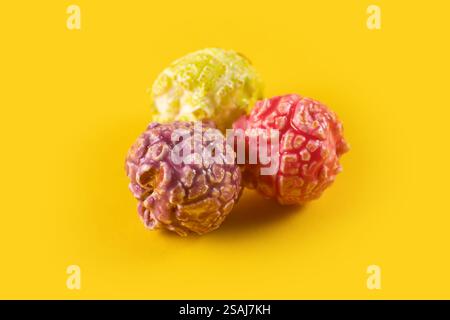 Colored fruity popcorn on yellow background. Stock Photo