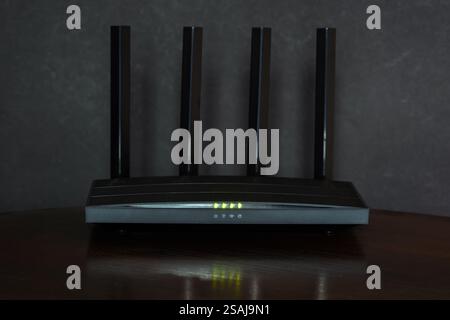 Wi-Fi router on black wooden table in room.. Stock Photo