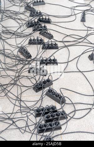Chaotically arranged electrical cables and splitters. Stock Photo