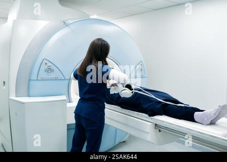 A nurse or medical technician prepares a patient for an MRI scan or MRI scanner Stock Photo
