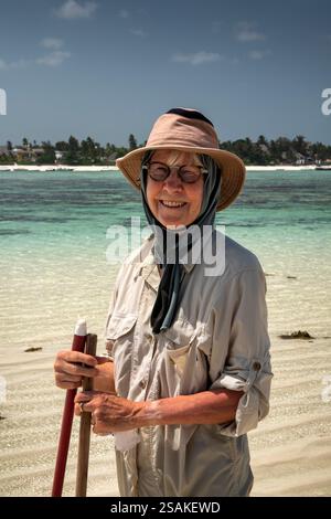 Africa Tanzania, Zanzibar, East Coast, Matemwe, reef walk at low tide, senior female tourist wet after walking through lagoon Stock Photo