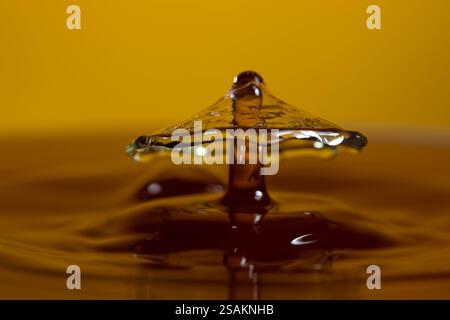 Splashart water collision on yellow background Stock Photo