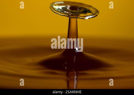 Splashart water collision on yellow background Stock Photo