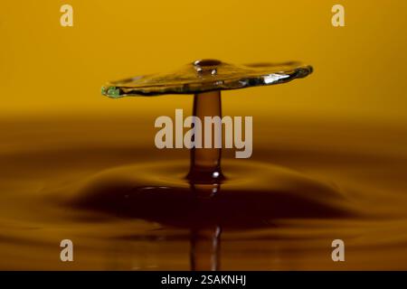 Splashart water collision on yellow background Stock Photo