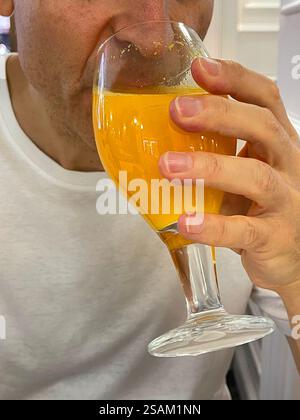 Man drinking a glass of orange juice. Stock Photo