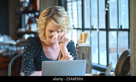 Female Fashion Designer In Creative Industry Sitting At Desk Using Laptop In Studio Stock Photo