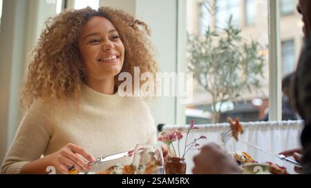 Young Couple Enjoying Meal On Date In City Restaurant Together Stock Photo