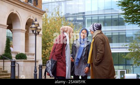 Group Of Young British Muslim Businesswomen Meeting And Talking Outside Office Stock Photo