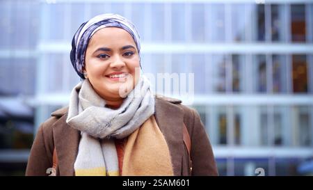 Portrait Of Smiling Young British Muslim Businesswoman Wearing Headscarf Outside Office Stock Photo