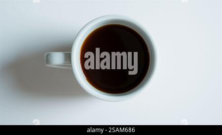 Overhead View Of Cup Of Fresh Black Coffee On White Background Stock Photo
