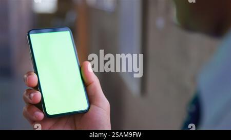 Over The Shoulder Close Up Shot Of Businessman Using Green Screen Mobile Phone Stock Photo