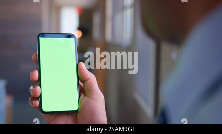 Over The Shoulder Close Up Shot Of Businessman Using Green Screen Mobile Phone Stock Photo