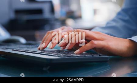 Close Up On Hands Of Businesswoman Sitting At Desk In Office Typing On Computer Keyboard Stock Photo