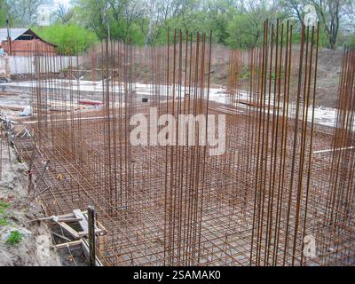Building foundation with rebar structure and formwork for column bases at an early stage. Stock Photo