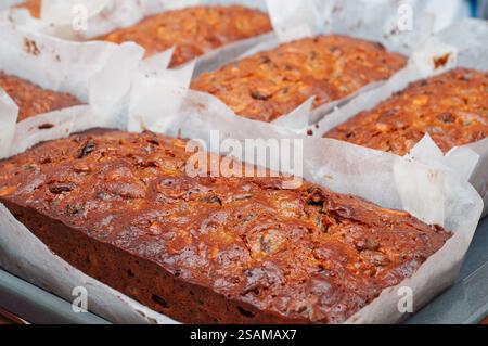Close-up of freshly baked fruit cakes in parchment-lined loaf pans. Stock Photo
