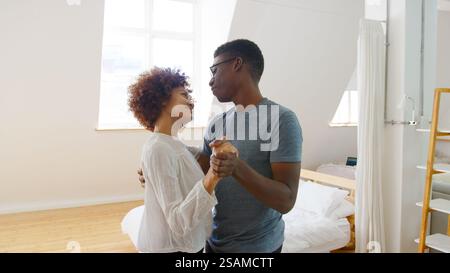 Young Romantic Couple Having Fun In New Home Or Apartment Dancing Together Stock Photo