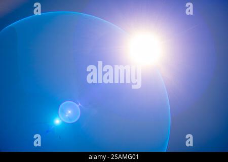Sunlight radiates against a deep blue sky, creating a tranquil atmosphere. Lens flares enhance the brightness, capturing the beauty of nature during daylight hours. Stock Photo