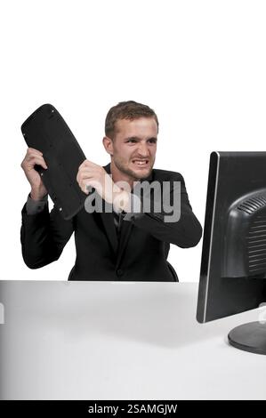 Angry man using a desktop computer for business Stock Photo