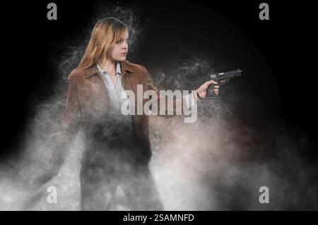 Beautiful young woman holding a loaded handgun Stock Photo