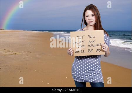 A beautiful young woman holding up a sign Stock Photo