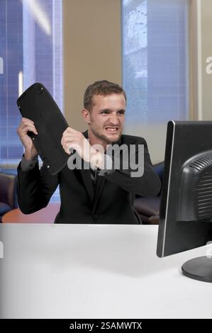Angry man using a desktop computer for business Stock Photo