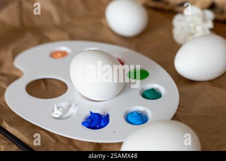 Creative egg decoration for Easter celebration with colorful paints and flowers Stock Photo