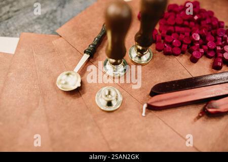 Sealing wax tools, red wax pellets on a brown envelope surface Stock Photo