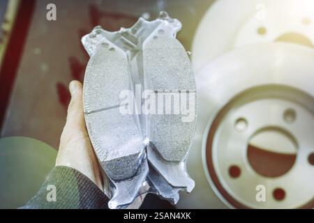 Packaged brake pads held by a hand with a sunlight effect, automotive focus Stock Photo