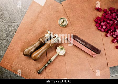 Sealing wax and tools on brown envelopes with red wax pellets Stock Photo