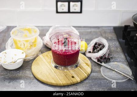 Kitchen scene showing smoothie ingredients and blender filled with smoothie mix Stock Photo