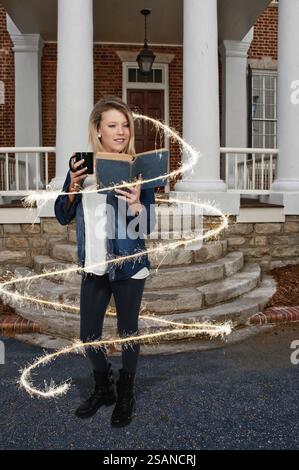 Beautiful woman reading a book while drinking a hot beverage Stock Photo