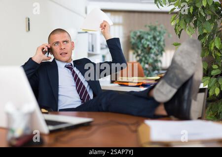 Irritated businessman having difficult phone talk Stock Photo