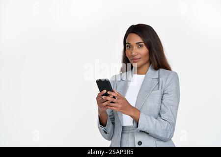 Confident African American business lady using phone isolated on white wall. Stock Photo