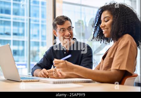 Diverse happy young business people two coworkers working together using laptop. Stock Photo