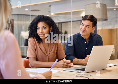 African female executive financial advisor consulting client at group meeting. Stock Photo
