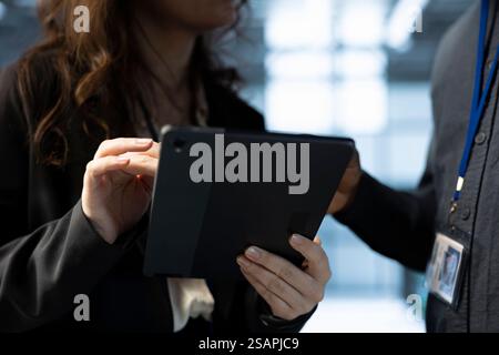 Team of technicians in data center using tablet to develop disaster recovery plans. Teamworking colleagues in server hub testing failover scenarios, protecting data during disruptions, closeup Stock Photo