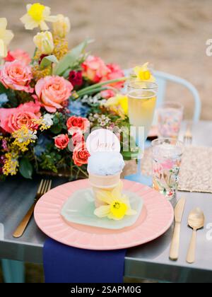 A vibrant outdoor setting features a beautifully arranged dessert table with ice cream, floral decorations, and refreshing drinks, perfect for a sprin Stock Photo