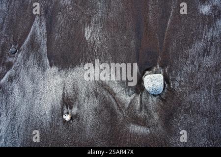 Background: nature's art graphic resource. A monochrome scene of black volcanic and golden sands mixed into diamond shapes by the sea on a beach Stock Photo