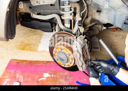 Mechanic working on replacing brake pads on vehicle Stock Photo - Alamy