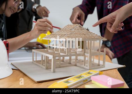 Group of an architect working and discussing about an architecture model together with shop drawing paper on table in office. Confident businesswoman Stock Photo