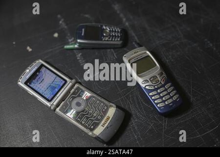 Three retro mobile phones presented on a black textured surface Stock Photo